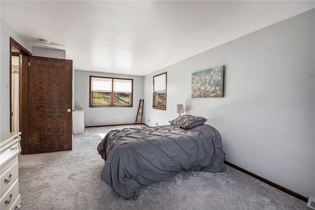 bedroom featuring visible vents, baseboards, and light colored carpet