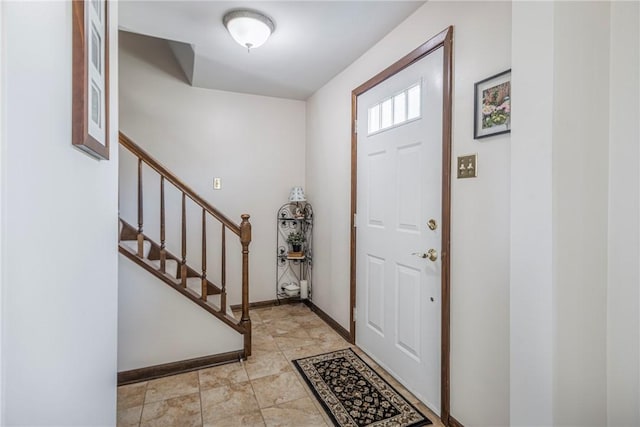 entrance foyer with stairs and baseboards