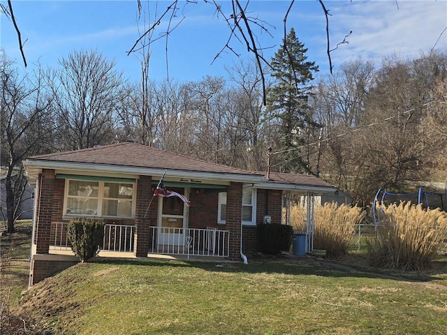 bungalow with a front yard, covered porch, and brick siding