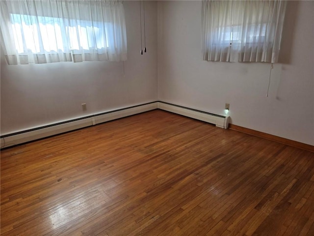 empty room with hardwood / wood-style flooring, baseboards, baseboard heating, and a baseboard radiator