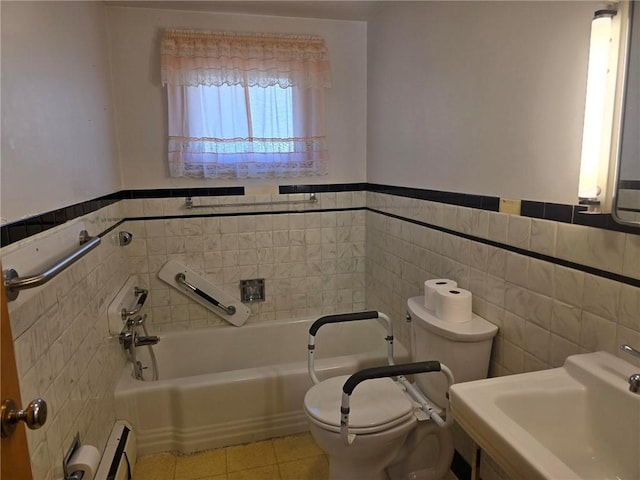 bathroom with tile patterned floors, a garden tub, toilet, a sink, and a baseboard heating unit