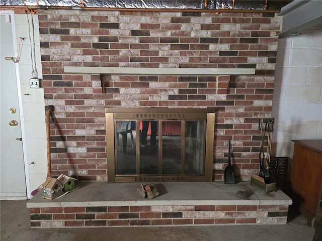 interior details with a brick fireplace and concrete floors