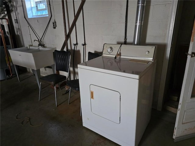 washroom with laundry area, washer / dryer, concrete block wall, and a sink