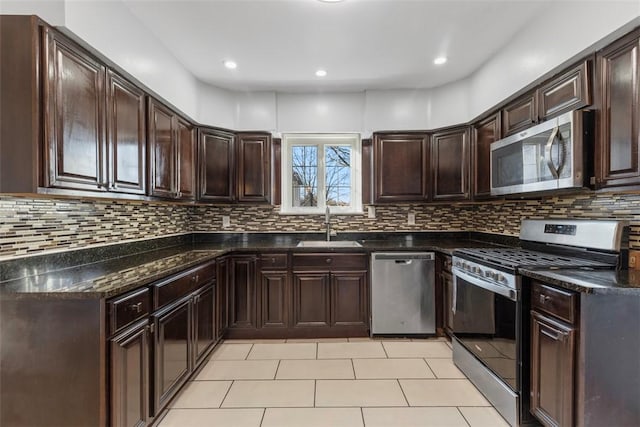 kitchen featuring light tile patterned floors, a sink, decorative backsplash, dark brown cabinetry, and stainless steel appliances