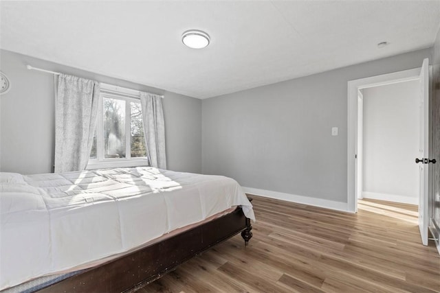 bedroom with wood finished floors and baseboards