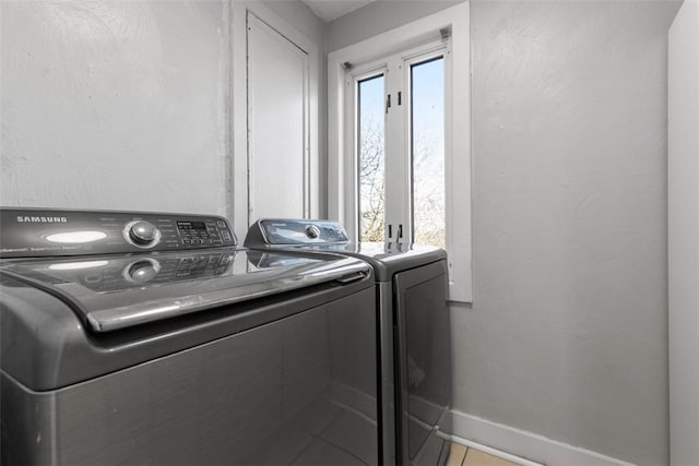 laundry area featuring laundry area, baseboards, and washing machine and clothes dryer