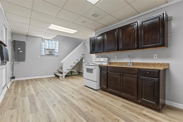 kitchen with white electric range, light wood finished floors, electric panel, and a sink