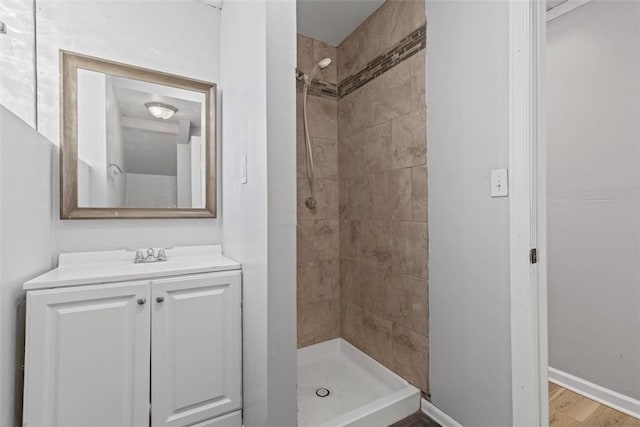 bathroom featuring baseboards, vanity, wood finished floors, and a shower stall