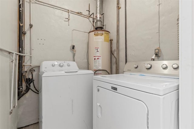 clothes washing area featuring gas water heater, laundry area, and washing machine and clothes dryer