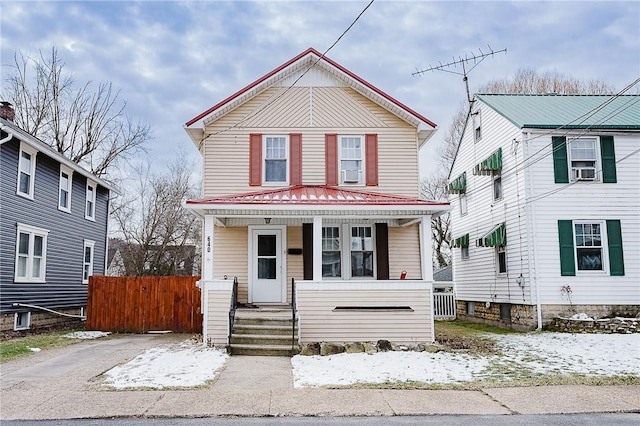 view of front of house featuring cooling unit, covered porch, and fence