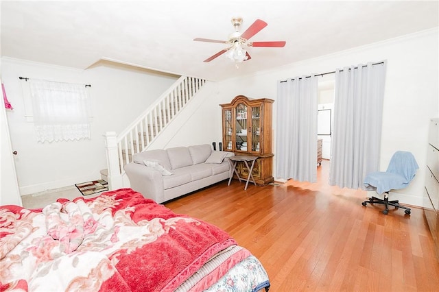 bedroom featuring baseboards, ceiling fan, crown molding, and hardwood / wood-style flooring