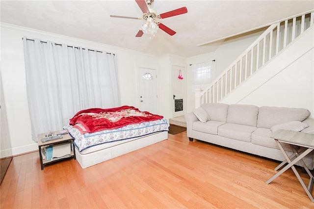 bedroom featuring ornamental molding, a ceiling fan, and wood finished floors