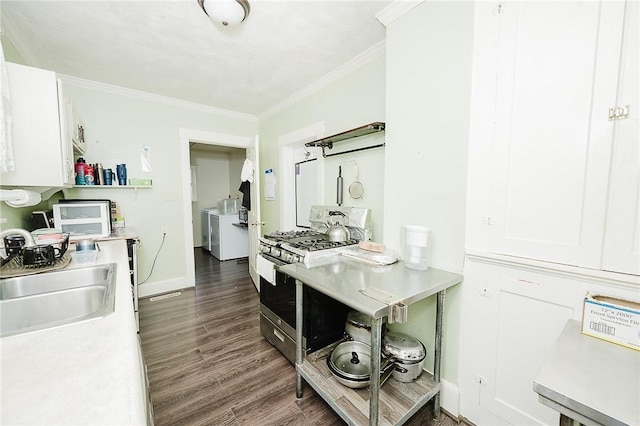 kitchen featuring dark wood-type flooring, washer and clothes dryer, light countertops, gas range oven, and a sink