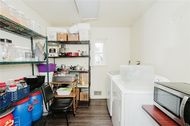 clothes washing area featuring visible vents, separate washer and dryer, wood finished floors, and laundry area