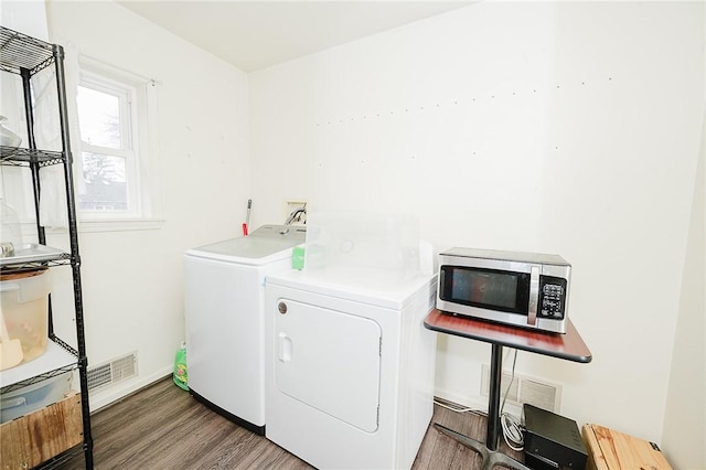 clothes washing area with laundry area, wood finished floors, independent washer and dryer, and baseboards