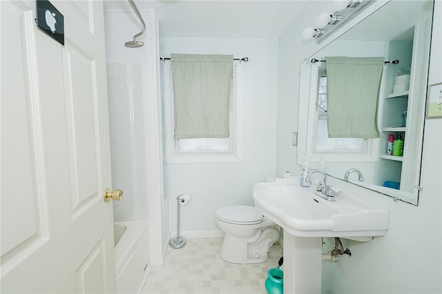 bathroom with toilet, shower / tub combination, and baseboards