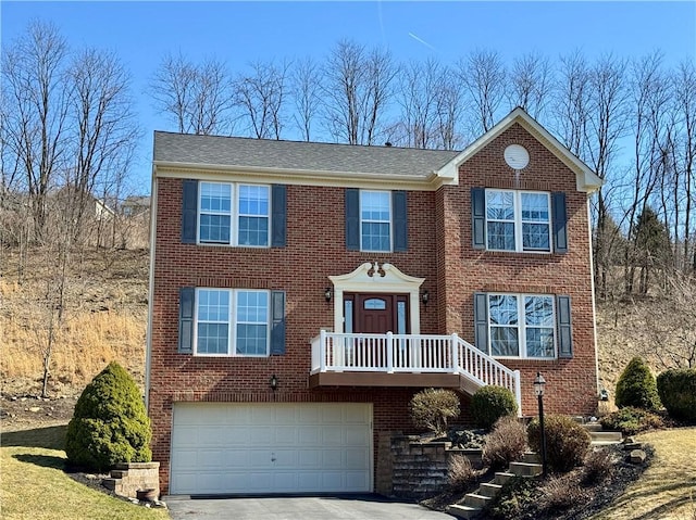 view of front of property featuring a garage, brick siding, and driveway