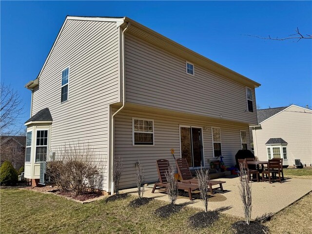 rear view of property featuring a patio area and a lawn