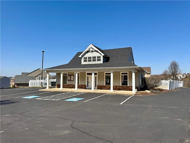 view of building exterior featuring uncovered parking and fence