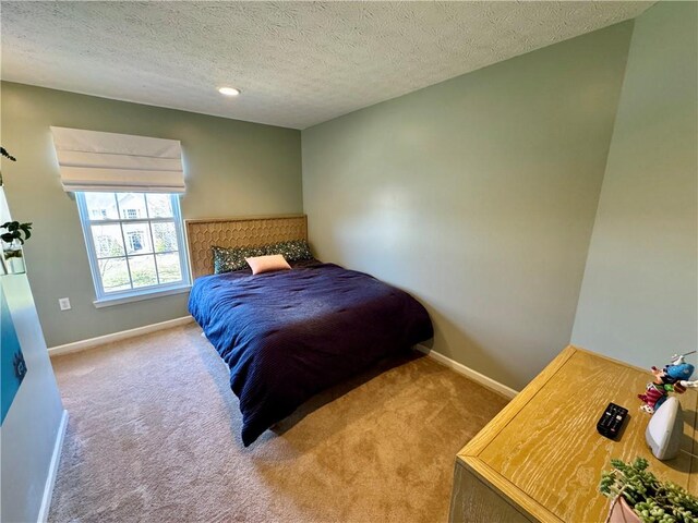 bedroom with baseboards, carpet, and a textured ceiling