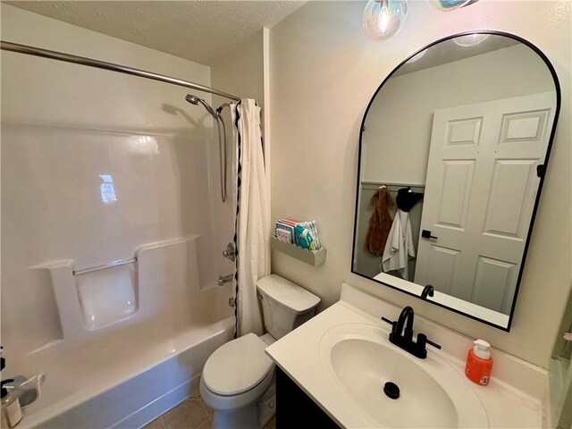 bathroom with shower / bath combo with shower curtain, toilet, a textured ceiling, tile patterned flooring, and vanity