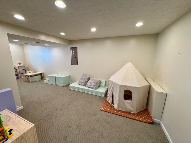 playroom featuring electric panel, a textured ceiling, recessed lighting, carpet, and baseboards