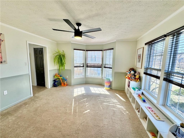 rec room with plenty of natural light, carpet, and ornamental molding