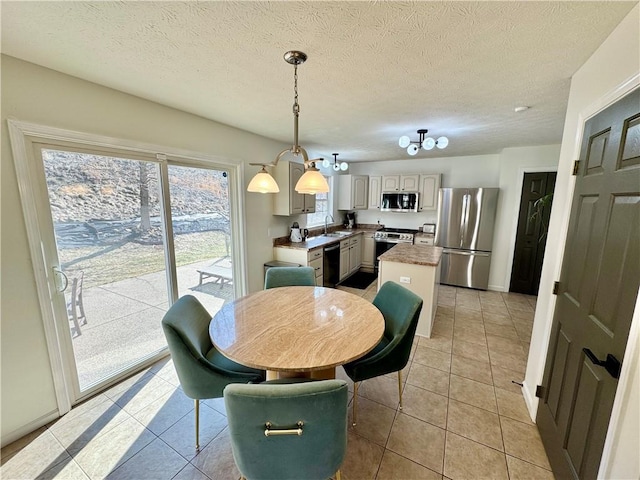 dining space featuring light tile patterned flooring and a textured ceiling