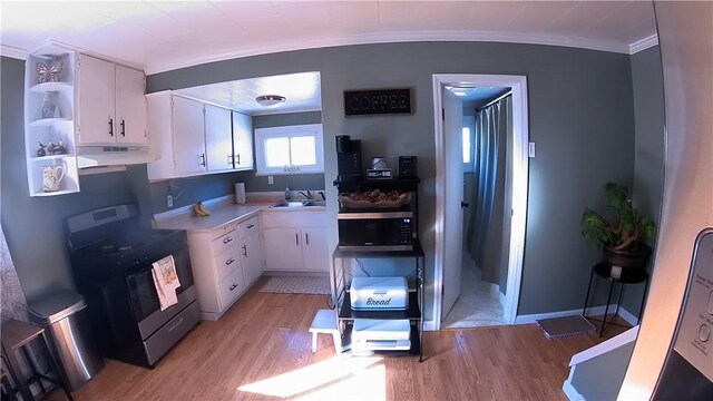 kitchen featuring under cabinet range hood, open shelves, white cabinetry, crown molding, and range