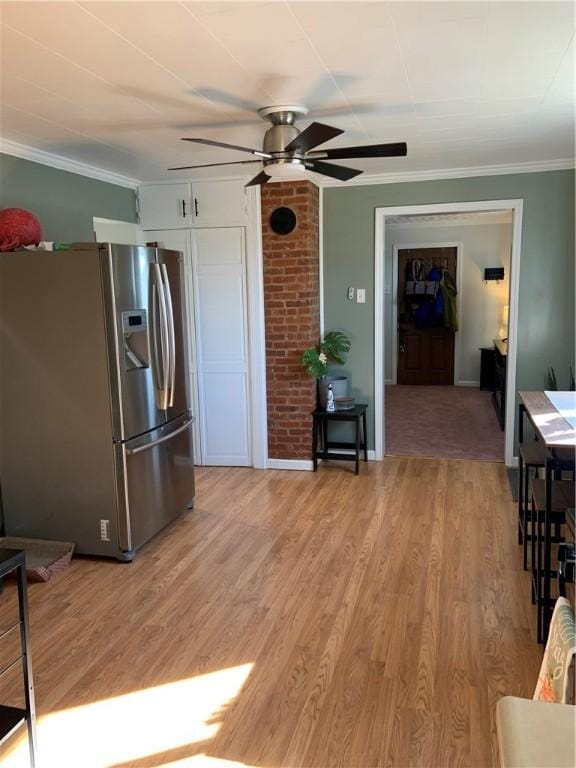 kitchen with crown molding, light wood-type flooring, white cabinets, stainless steel fridge, and a ceiling fan