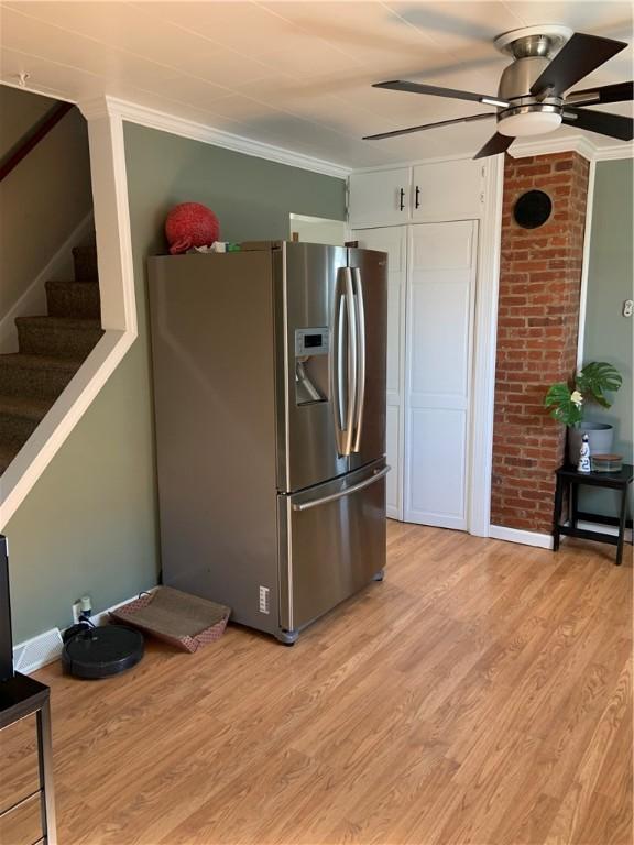 kitchen with light wood-style flooring, a ceiling fan, crown molding, and stainless steel refrigerator with ice dispenser