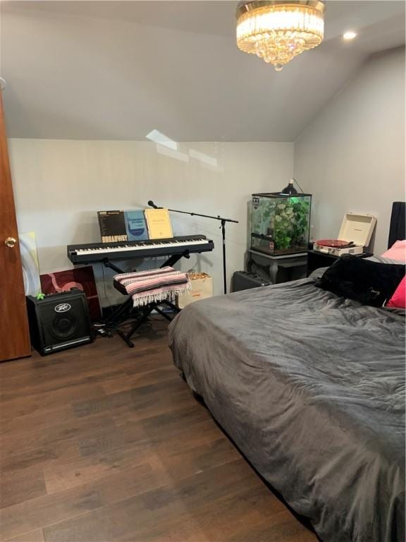 bedroom with vaulted ceiling, wood finished floors, and a chandelier