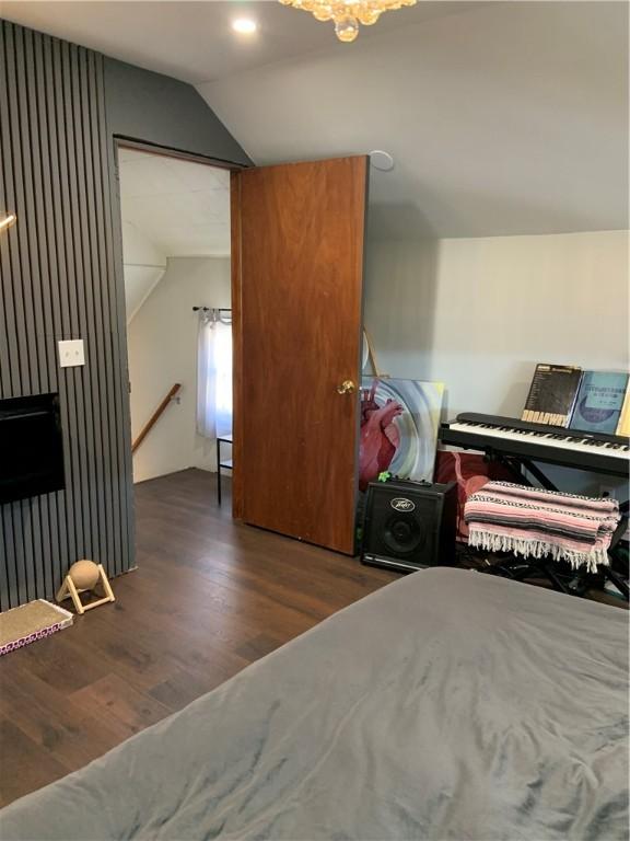 bedroom with wood finished floors and vaulted ceiling