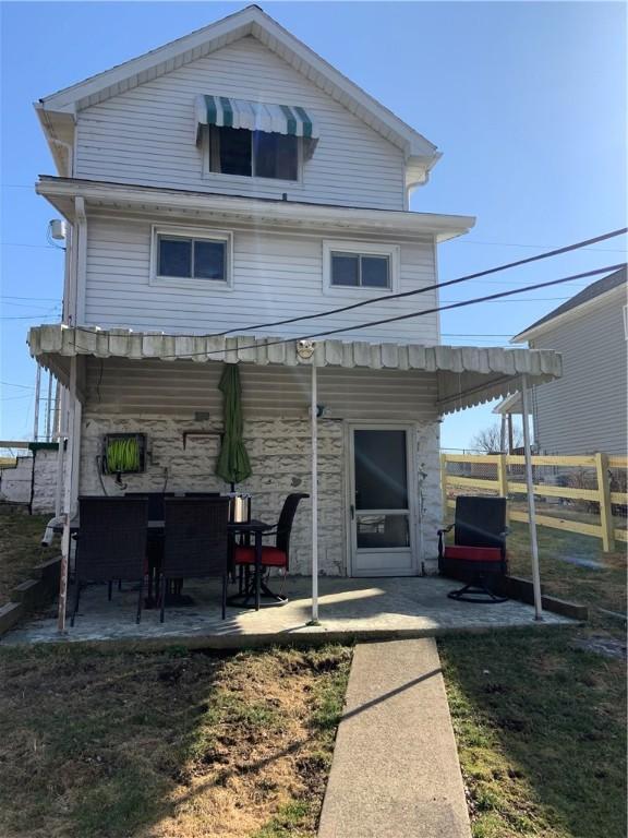 back of property featuring a patio area, fence, and stone siding