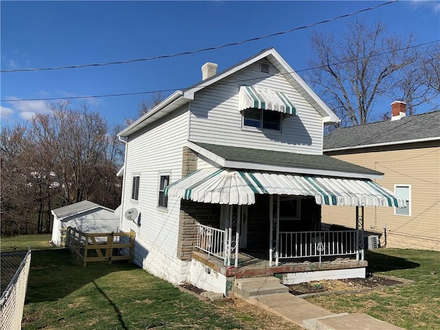 view of front facade featuring a front yard, central AC unit, covered porch, and a chimney