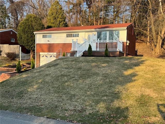 manufactured / mobile home featuring a garage, brick siding, and a front lawn