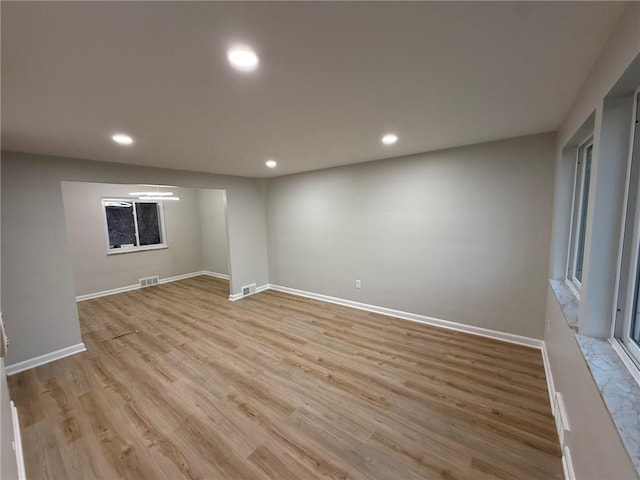 spare room with light wood finished floors, visible vents, recessed lighting, and baseboards