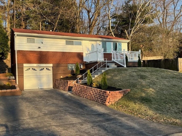 ranch-style house featuring a front yard, an attached garage, brick siding, and driveway