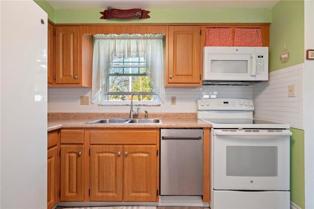 kitchen with a sink, decorative backsplash, white appliances, and light countertops