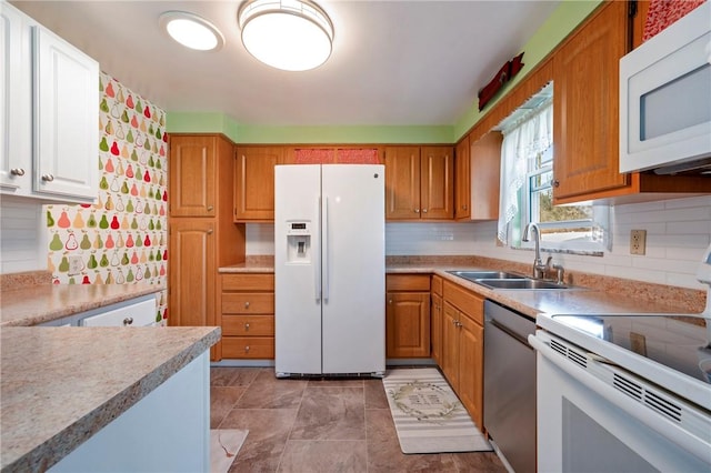 kitchen with white appliances, light countertops, tasteful backsplash, and a sink