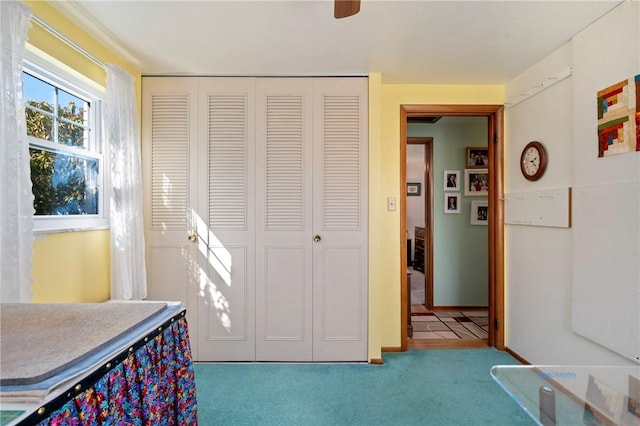 carpeted bedroom with a closet and ceiling fan