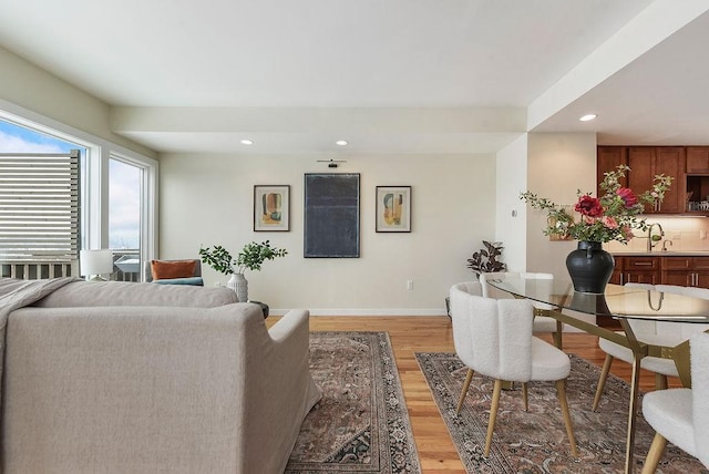 living area featuring recessed lighting, light wood-type flooring, and baseboards