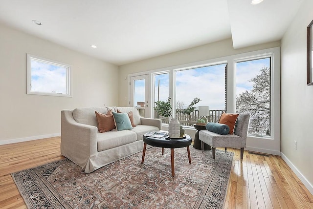 living room with recessed lighting, baseboards, and light wood finished floors