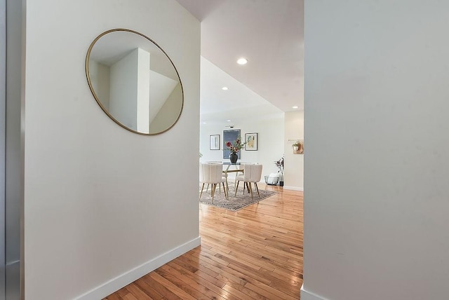 hall featuring recessed lighting, baseboards, and light wood-style floors