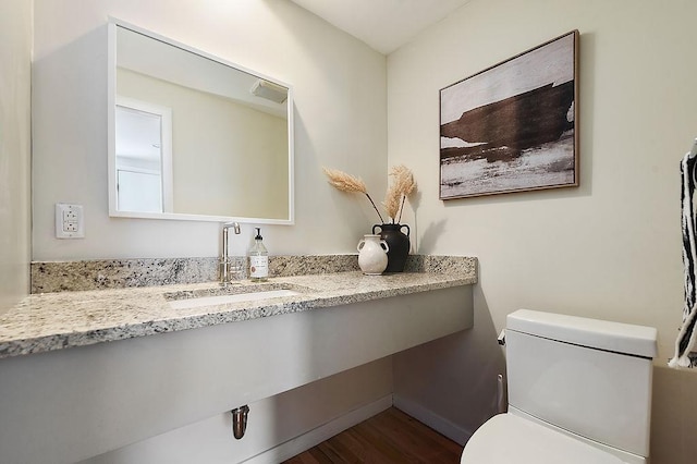 bathroom with vanity, toilet, wood finished floors, and visible vents