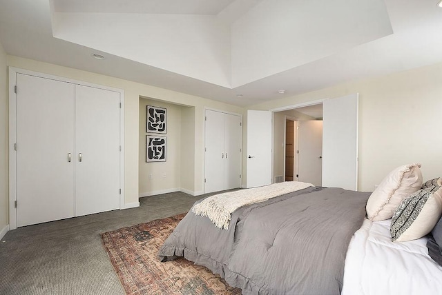 bedroom with carpet, baseboards, multiple closets, and high vaulted ceiling