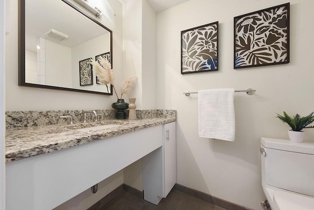 bathroom featuring tile patterned flooring, toilet, vanity, and baseboards