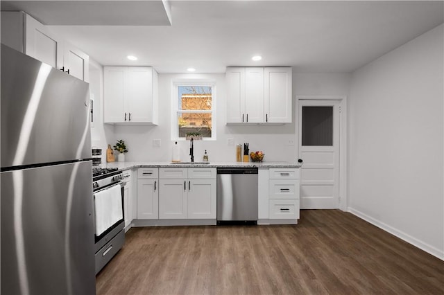 kitchen with white cabinetry, wood finished floors, appliances with stainless steel finishes, and a sink