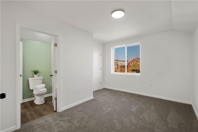 unfurnished bedroom featuring lofted ceiling, carpet, and baseboards