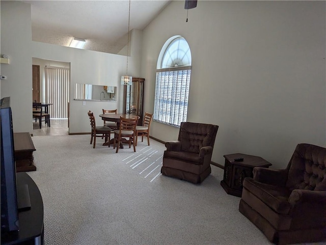 sitting room featuring baseboards, high vaulted ceiling, and carpet